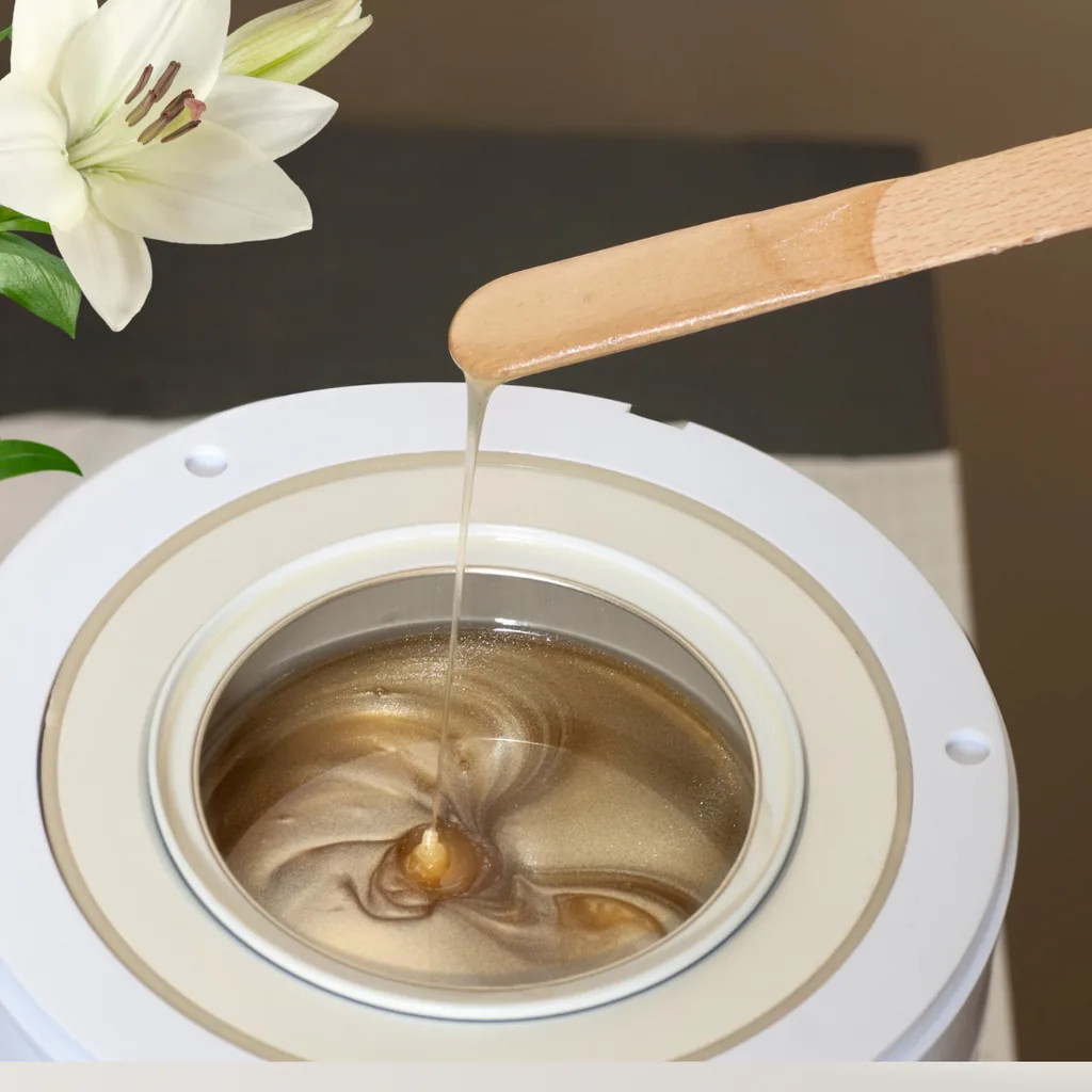 A warm wax pot and a single white lily on the waxing station